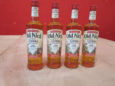 Quatre bouteilles de sirop de vanille « Old Nick » sont posées sur une table en bois