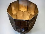 a metal bowl that is sitting on a white surface