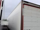 a white truck with a red stripe parked next to another truck