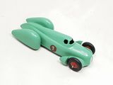 a green toy car with red wheels on a white surface