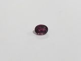 a close up of a purple gemstone on a white surface