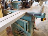 a machine that is cutting a piece of wood on a table