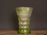 un vase en verre vert posé sur une table en bois