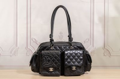 a black purse sitting on a table in front of a wall