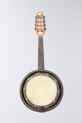 a banjo hanging from a string with a guitar in the background