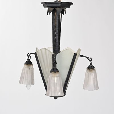 un lustre muni de trois abat-jours en verre suspendu au plafond