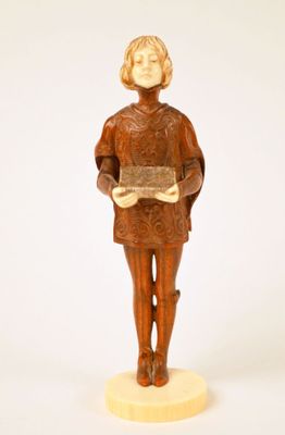 wooden figurine of a man holding a book on a white surface