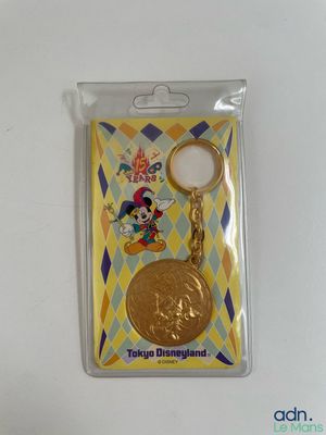 a close up of a keychain with a gold coin on it