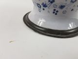 a blue and white vase on a stand on a table