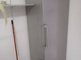 a silver refrigerator in the corner of a room