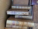 several old books stacked on top of each other in a room