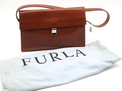 un porte-monnaie en cuir marron, avec un sac blanc à côté