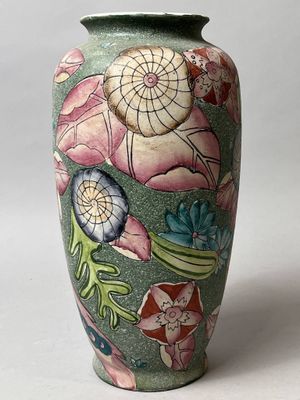 un vase vert orné d'un motif floral