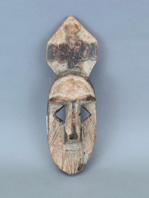 une image représentant un masque en bois sur lequel figure un visage