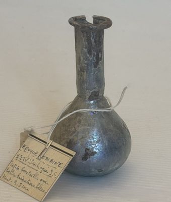 un petit vase en métal muni d'une étiquette