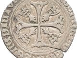 an old silver coin with a cross on the front of it