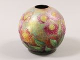 a colorful vase with flowers painted on it on a white surface