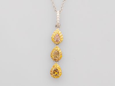 a yellow and white diamond pendant on a silver chain