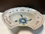 a white bowl with blue flowers on it sitting on a table