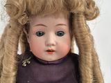 a doll with long blonde hair and a purple dress