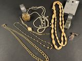 a group of jewelry including a watch, bracelets, and a necklace