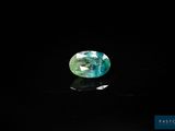 a blue and green tourmaline gems on a black surface
