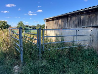 une clôture devant une grange, avec la grange en arrière-plan