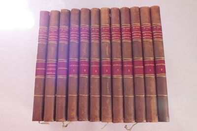 plusieurs vieux livres sont alignés sur une surface blanche
