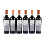 three bottles of red wine are lined up on a white surface