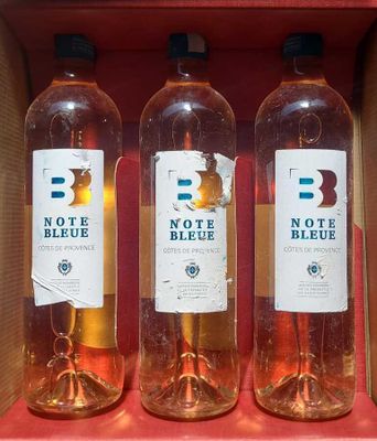 three bottles of wine in a cardboard box on a shelf