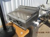 a grill that is sitting on a table in front of a building