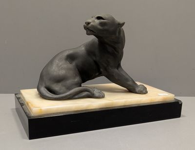 statue d'un chat assis sur un socle en marbre posé sur une table