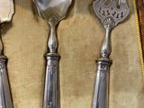 three silver spoons and a fork in a case