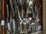 un plateau en bois sur lequel sont posés des couverts et des cuillères