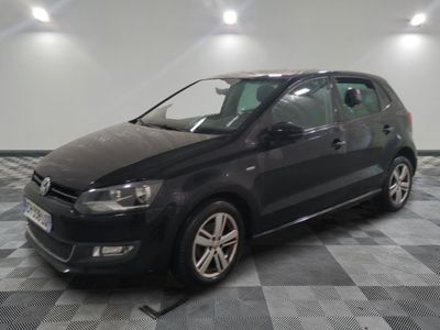 the black volkswagen polo is parked on a checkered tile floor