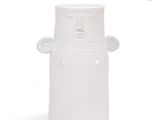 a white vase with a face on the side of it