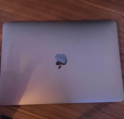 apple laptop sitting on a wooden table with a keyboard and mouse