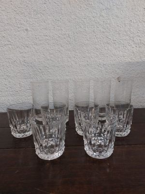 Quatre verres sont alignés sur une table, avec un mur blanc en arrière-plan.