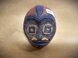 an image of a ceramic mask on a leather surface