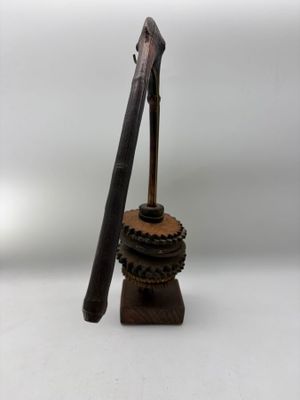 a small wooden object with a wooden stick on top of it
