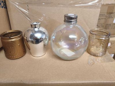 trois bocaux en verre posés sur une boîte en carton