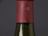 a bottle of wine that has a red cap on it