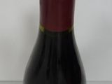 a bottle of wine sitting on a table next to a bottle of wine