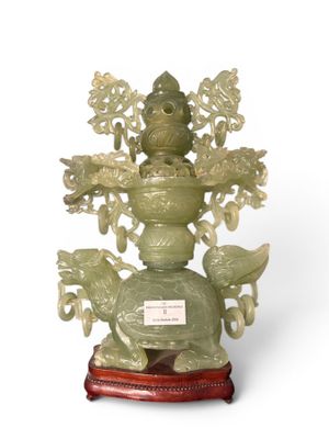a green vase with a bird on top of it