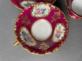 three cups and saucers on a table with a cup and saucer