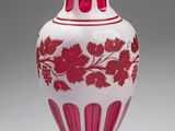un vase rose et blanc posé sur une surface blanche