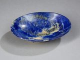 blue and white bowl on a table with a shadow on the surface
