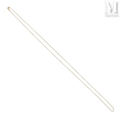 un gros plan sur un collier en or à longue chaîne
