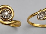 two gold rings with diamonds on them sitting on a table