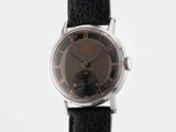a close up of a watch on a black strap on a white surface